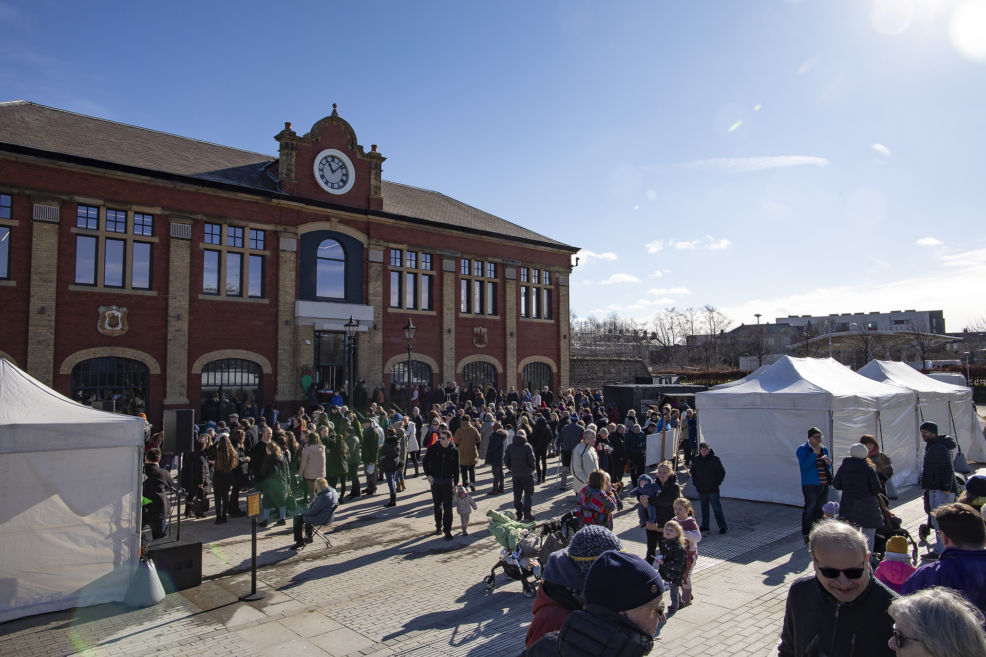 Image of the Granton Station Square launch event in March 2022, with people gathered at the square and marquees.